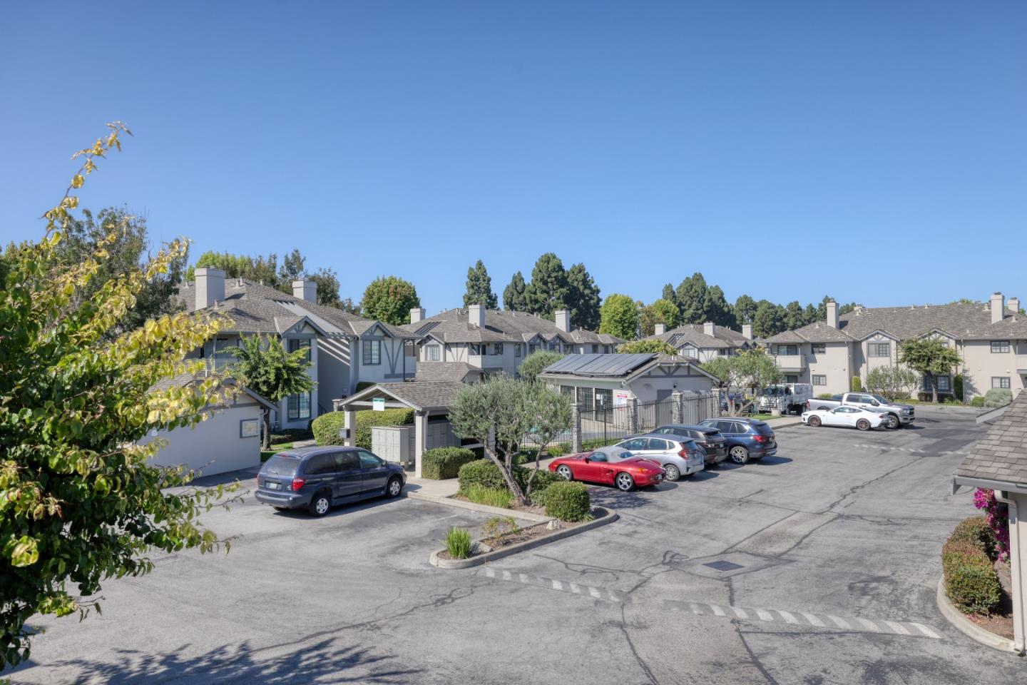 Residential complex with a gated entrance and cars parked in the lot.