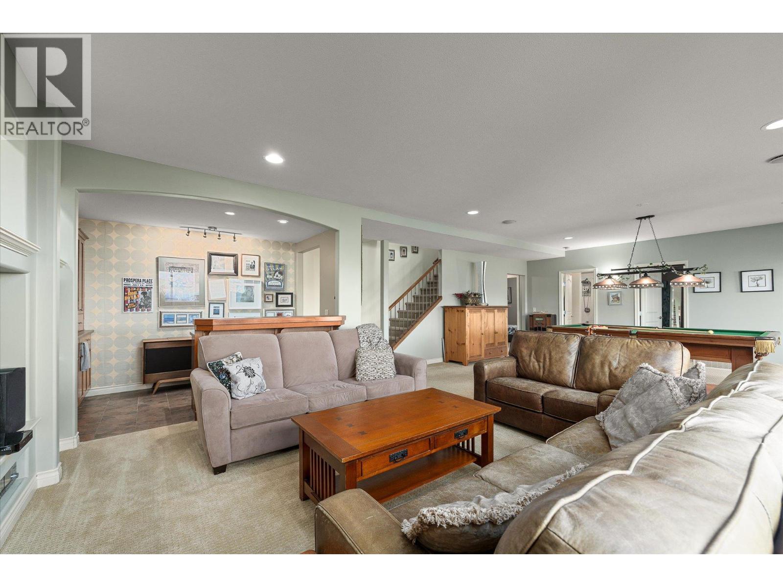 Furnished recreation room with sofas, a wooden coffee table, and a pool table.