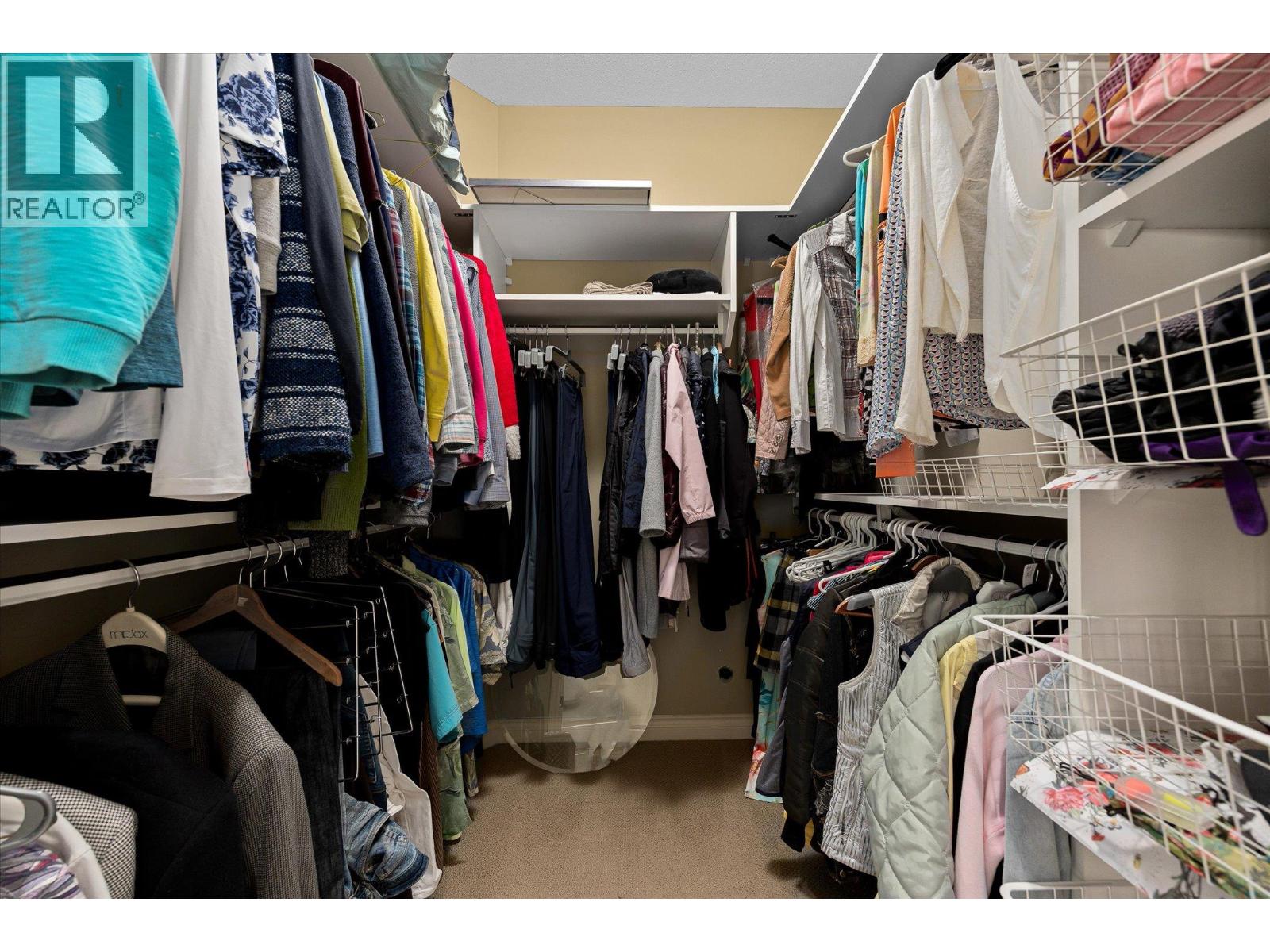 Walk-in closet with extensive clothing storage, wire baskets, and shelving.