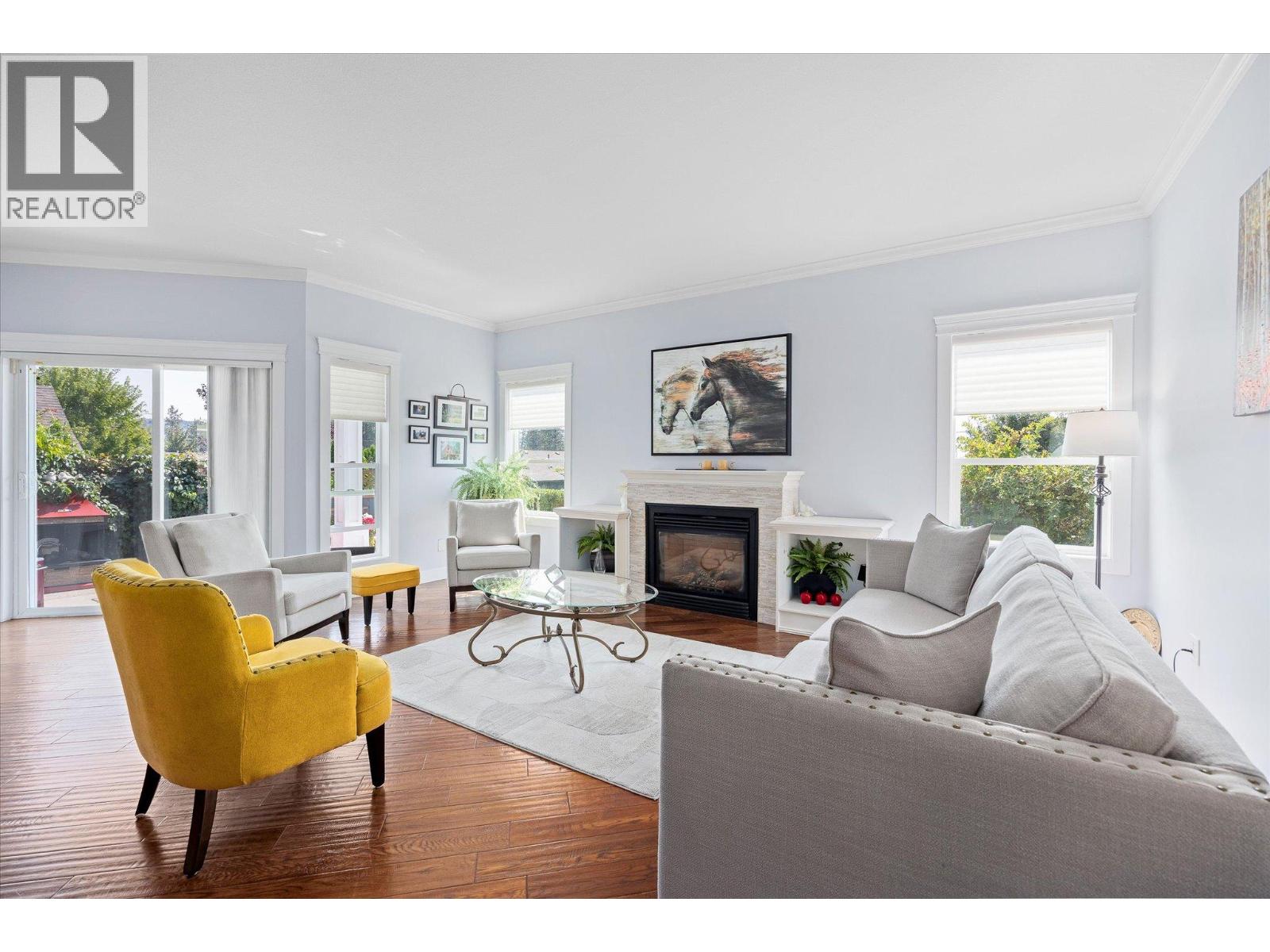 Furnished living room with a fireplace, hardwood floors, and a mustard-yellow accent chair.