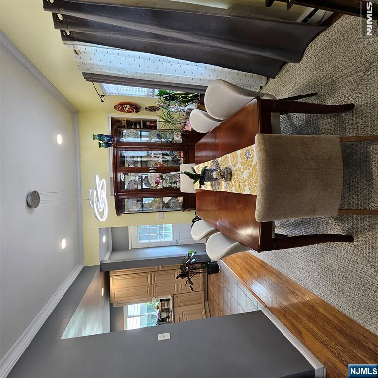 Dining room with a long wooden table, upholstered chairs, and a glass-front china cabinet.