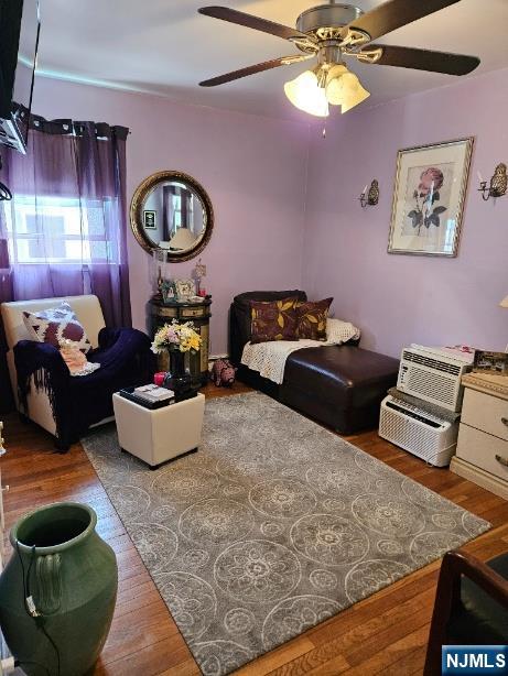 Living room with lavender walls, purple curtains, a ceiling fan, and a patterned rug.