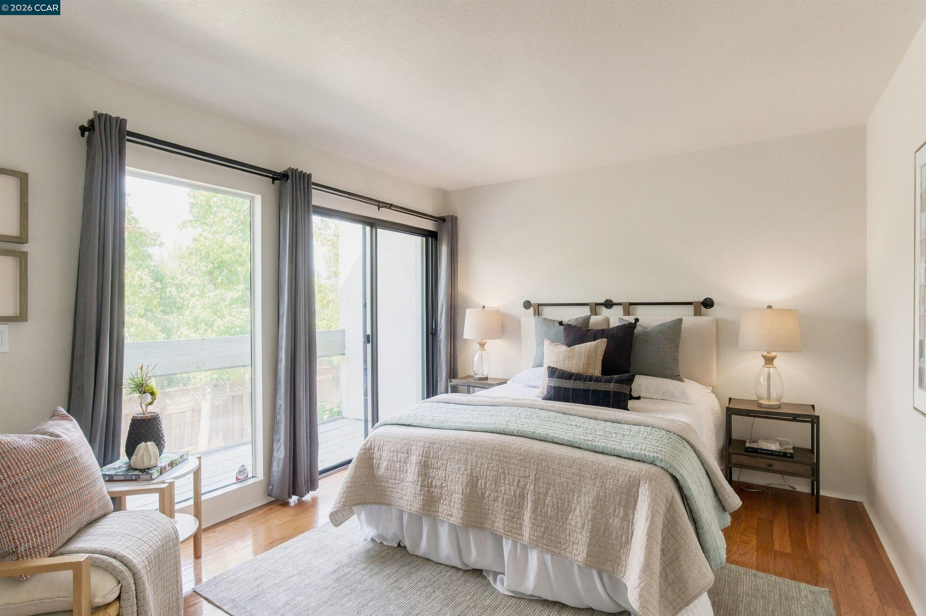 Furnished bedroom with a king bed and large sliding glass doors opening to a balcony.