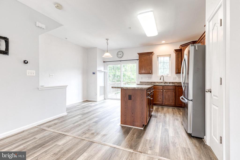 Vacant kitchen with a wood island, stainless steel appliances, and sliding glass doors to a deck.