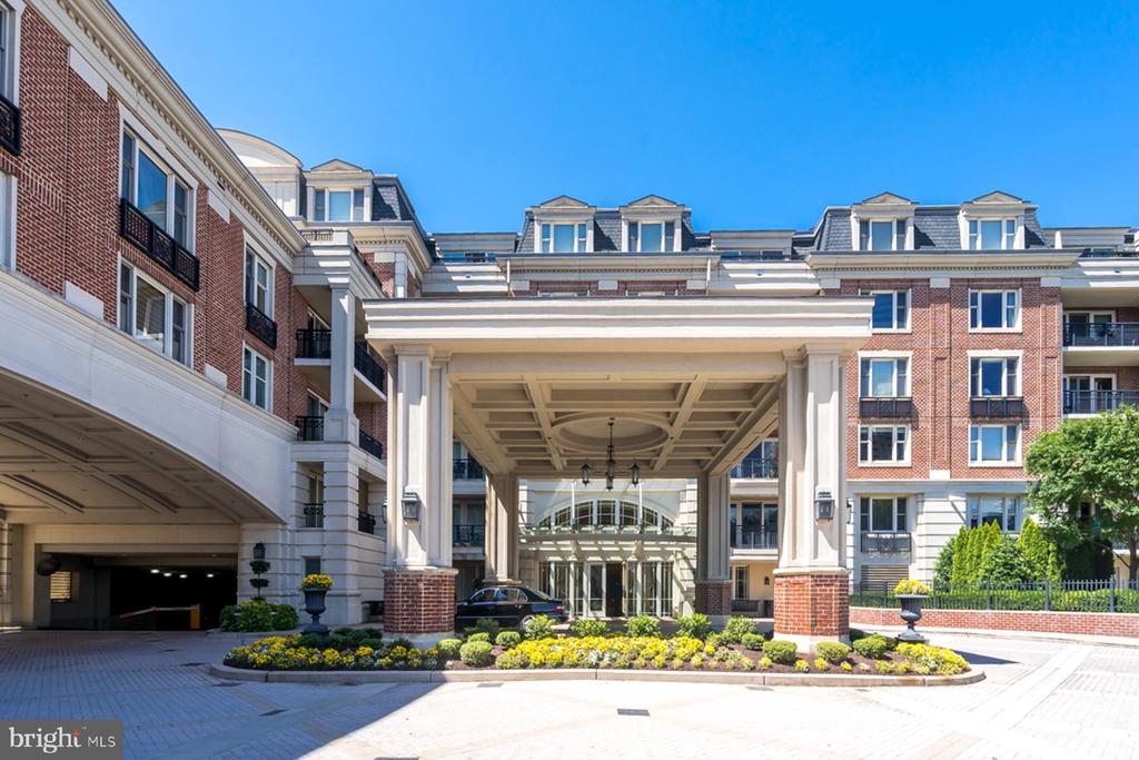 Red-brick residential building with a grand covered entrance and landscaped drive.