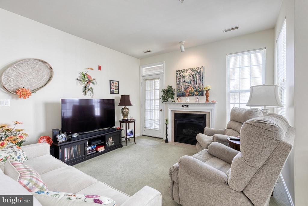 Living room with a fireplace, television, and reclining chairs.