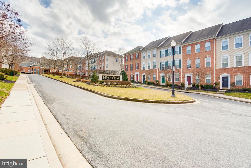 Townhouse community entrance with attached homes, a curved road, and a HighView sign.