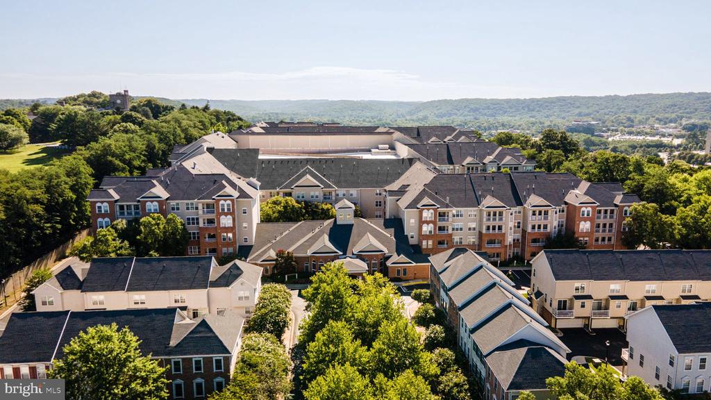 Aerial view of a residential complex surrounded by trees and wooded hills.