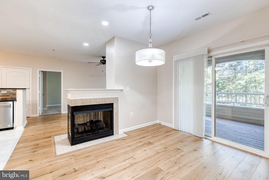 Vacant condo living area with a tiled fireplace and sliding glass doors to a balcony.