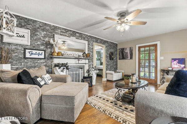 Living room with a gray sectional, stone fireplace wall, and glass-paneled doors.