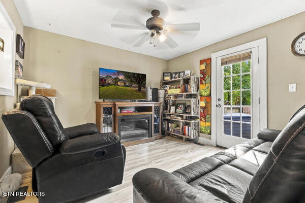 Living room with black leather recliners, a fireplace media console, and French doors to a patio.