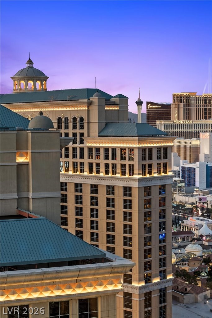 High-rise building overlooking the Las Vegas Strip at dusk, with teal roofs and illuminated architectural details.