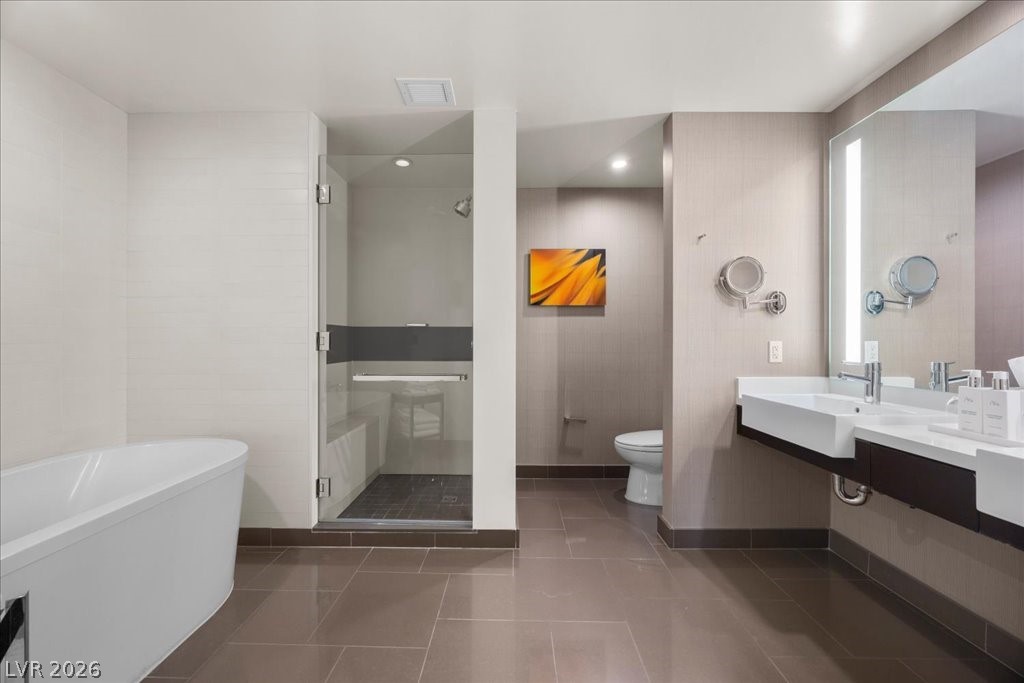 Modern bathroom with a freestanding tub, glass shower, and long double vanity.