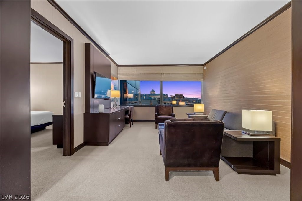 Furnished high-rise living area with leather seating and dusk city views through large windows.