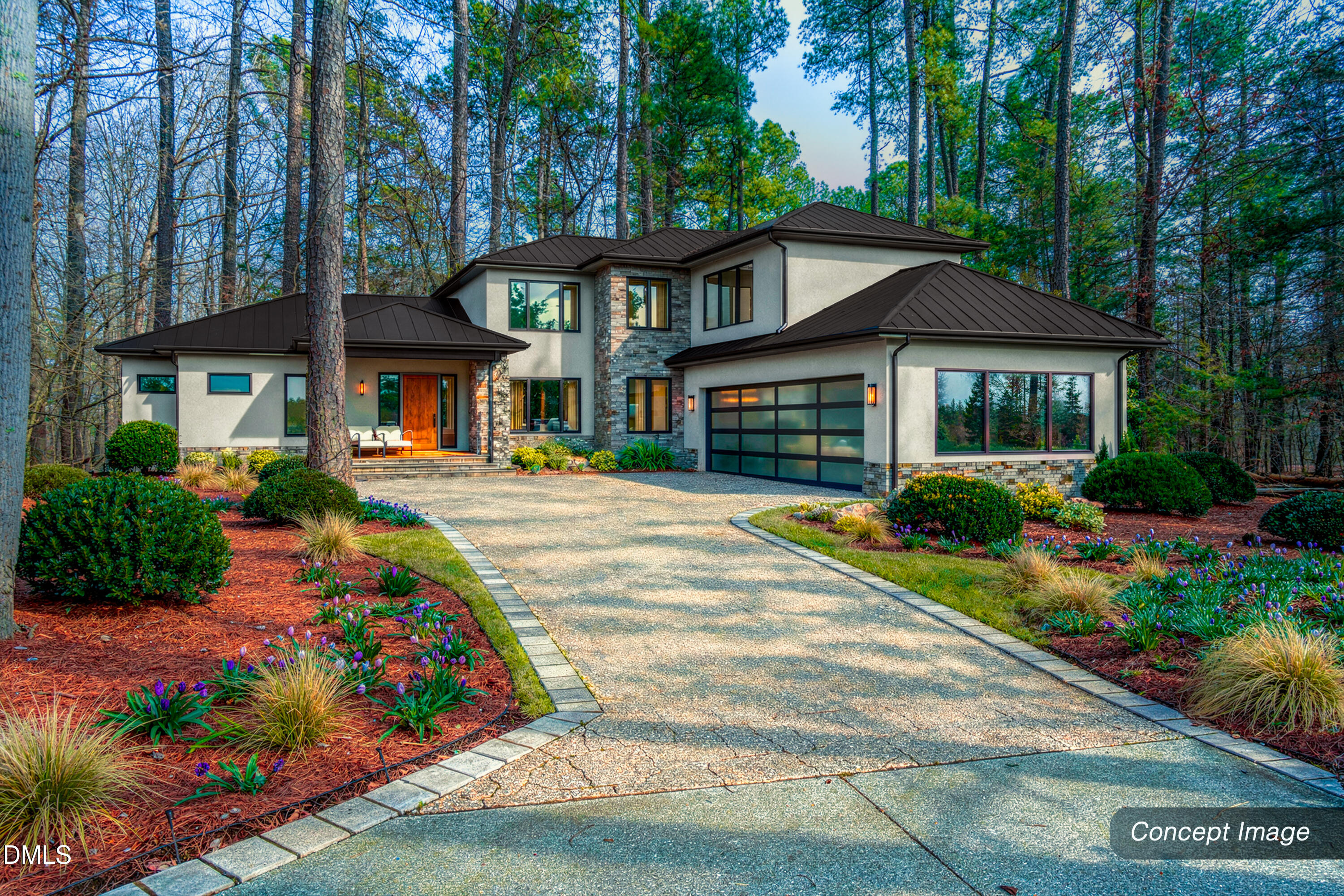 Modern home with stone accents and dark roofs, set among trees beside a landscaped curved driveway.