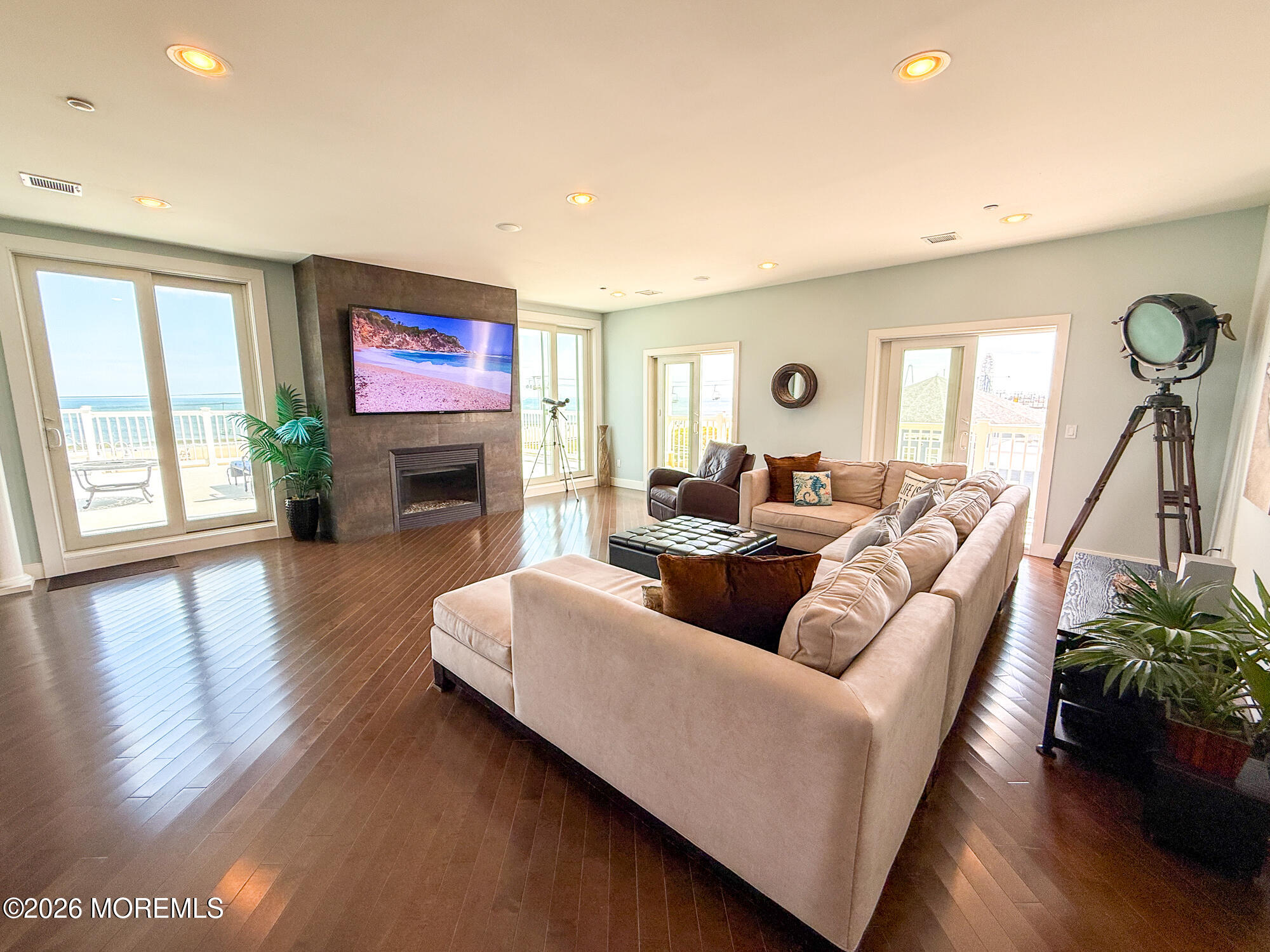 Furnished living room with a sectional sofa, fireplace, and sliding doors overlooking the ocean.