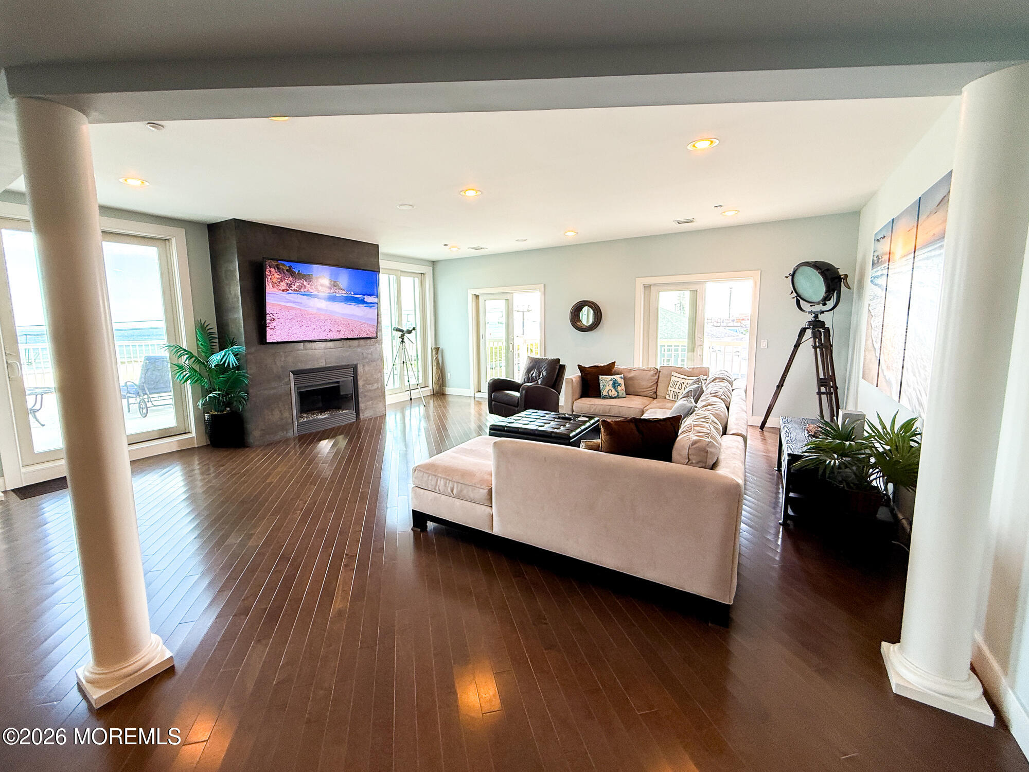 Furnished living room with a sectional, fireplace and ocean views through large windows.