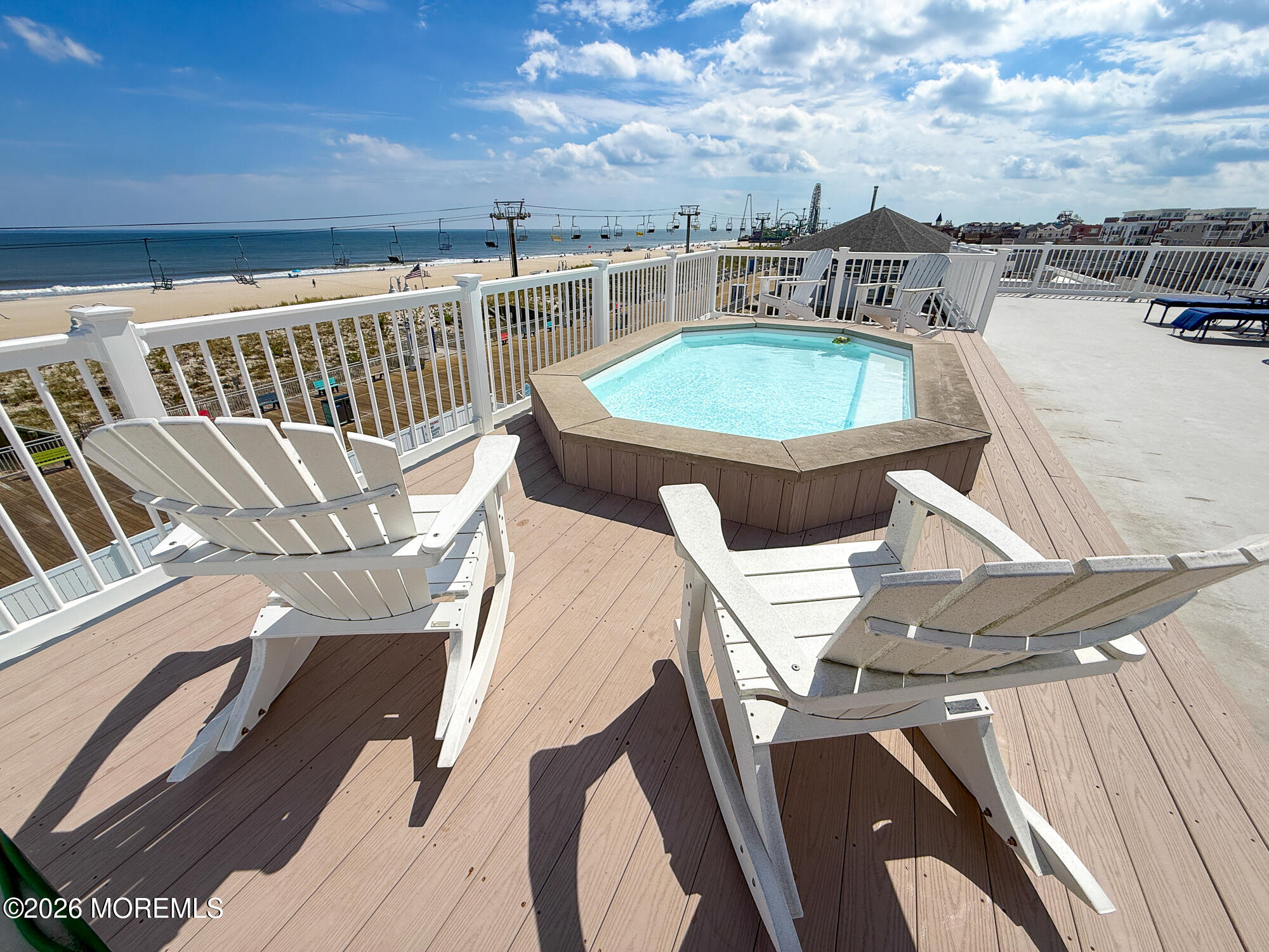 Rooftop hot tub and Adirondack chairs overlook the beach and ocean.