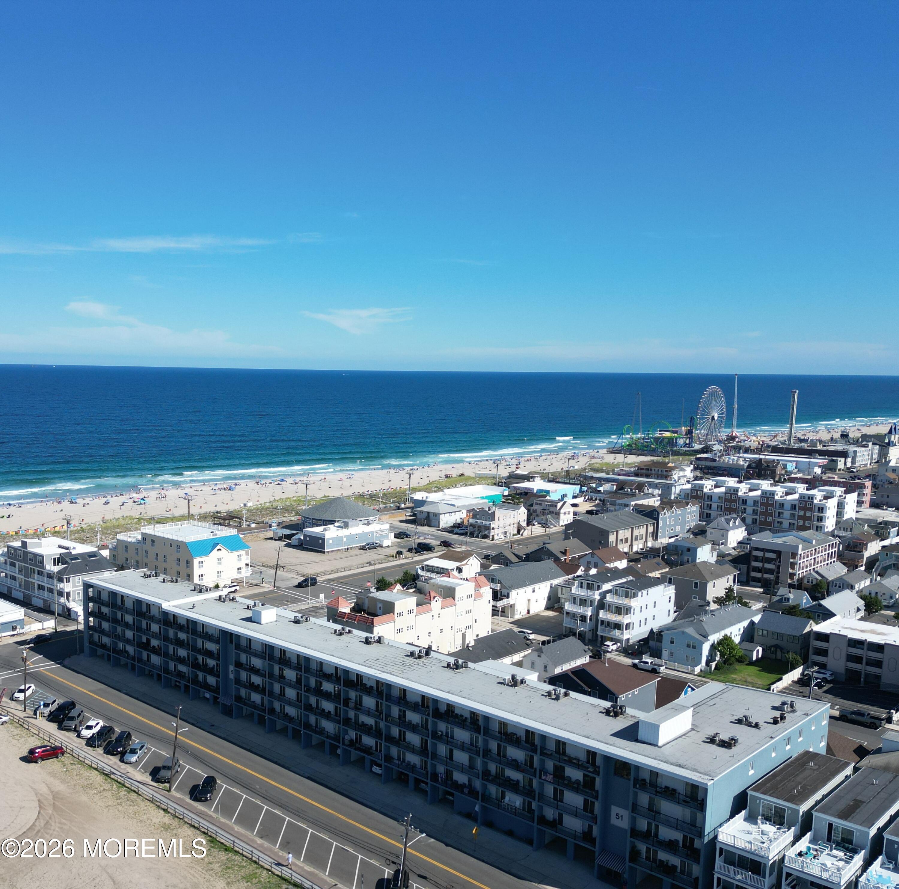 Aerial view of the beachfront condominium building, beach, ocean, and Seaside Heights Ferris wheel.
