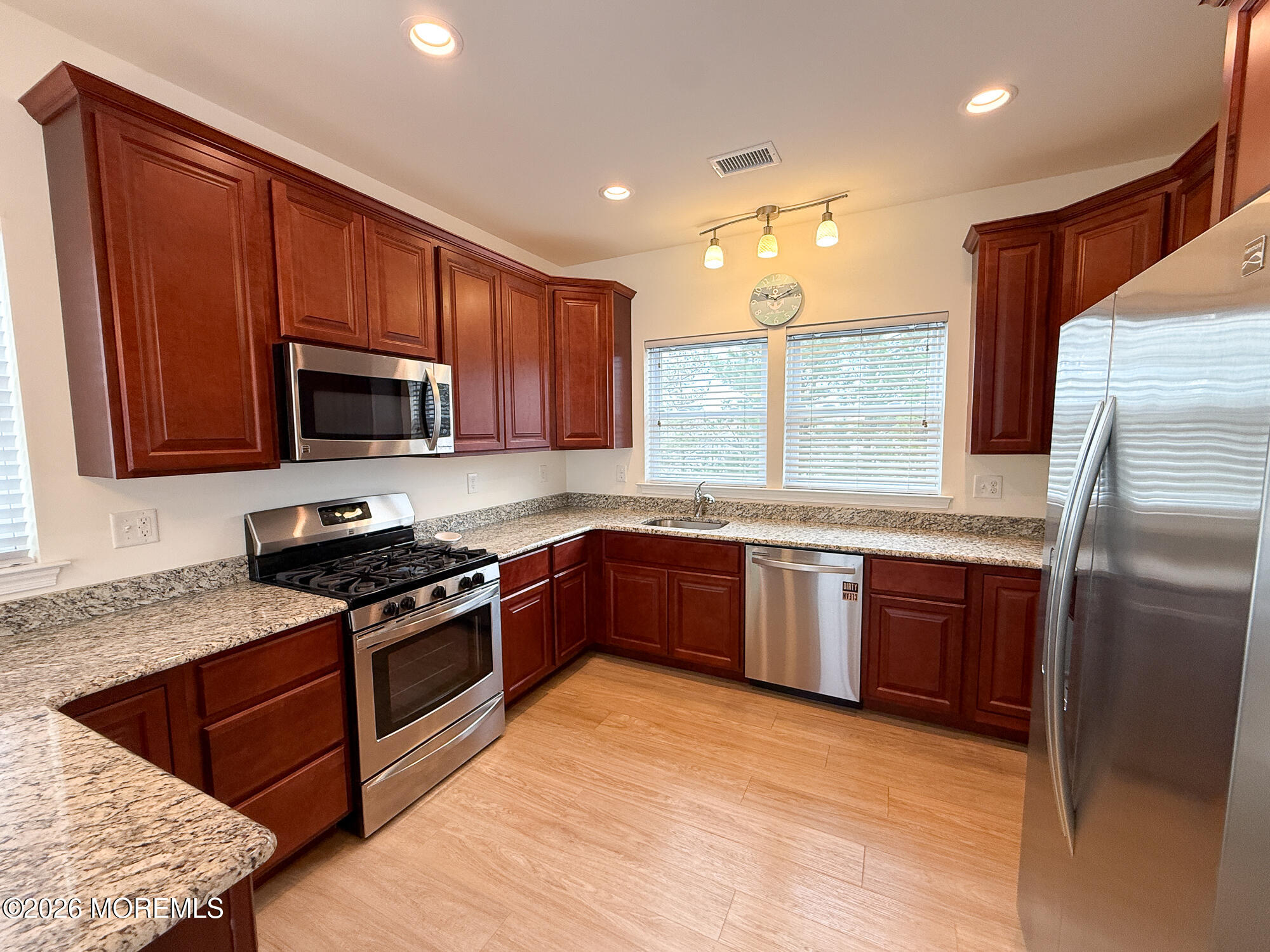 Kitchen with cherry cabinets, granite counters, and stainless steel appliances.