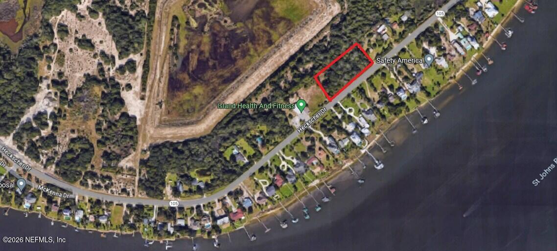 Wooded vacant parcel outlined in red beside Heckscher Drive, near the St. Johns River.