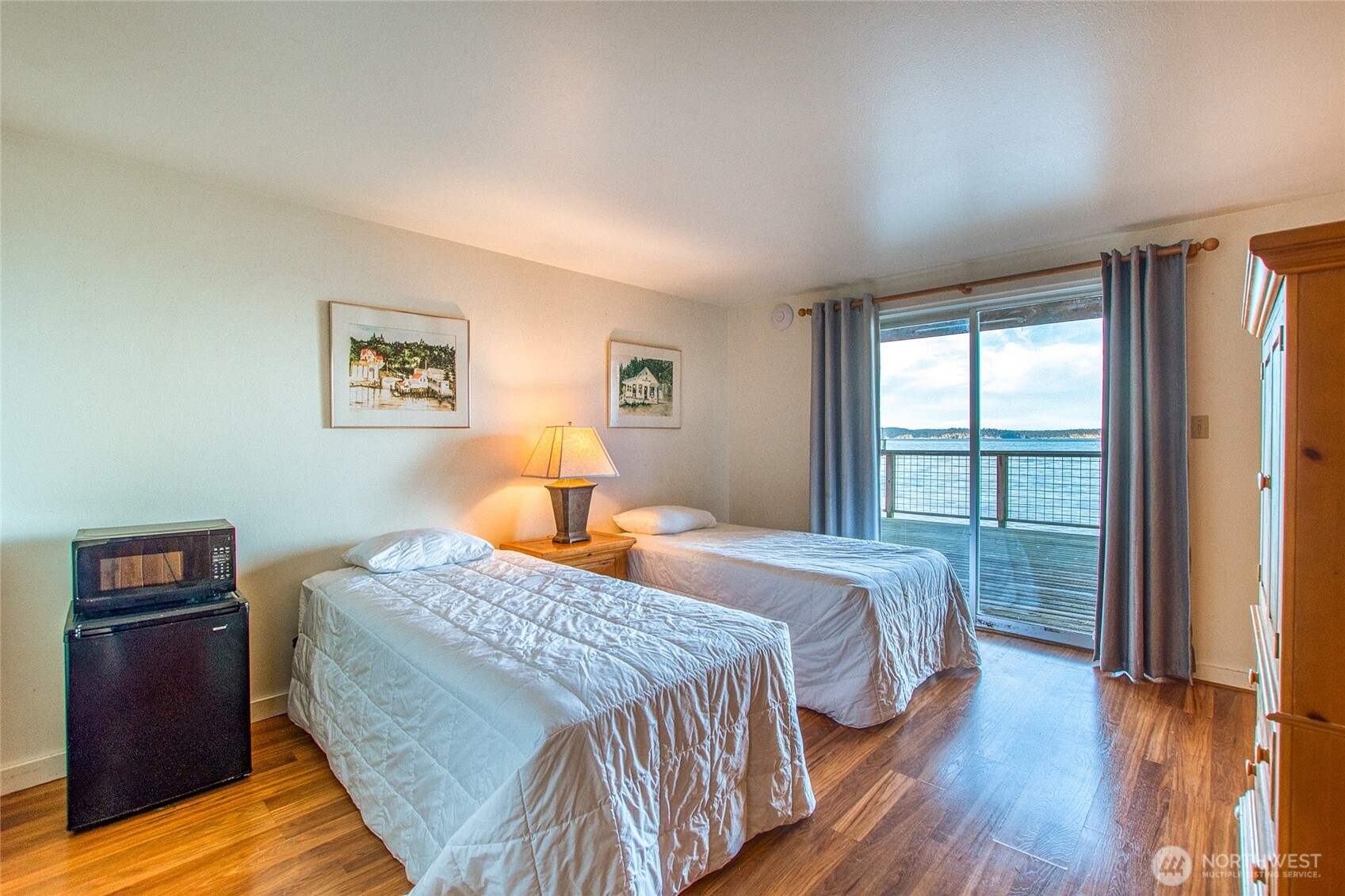 Bedroom with two twin beds and a sliding glass door overlooking the water.