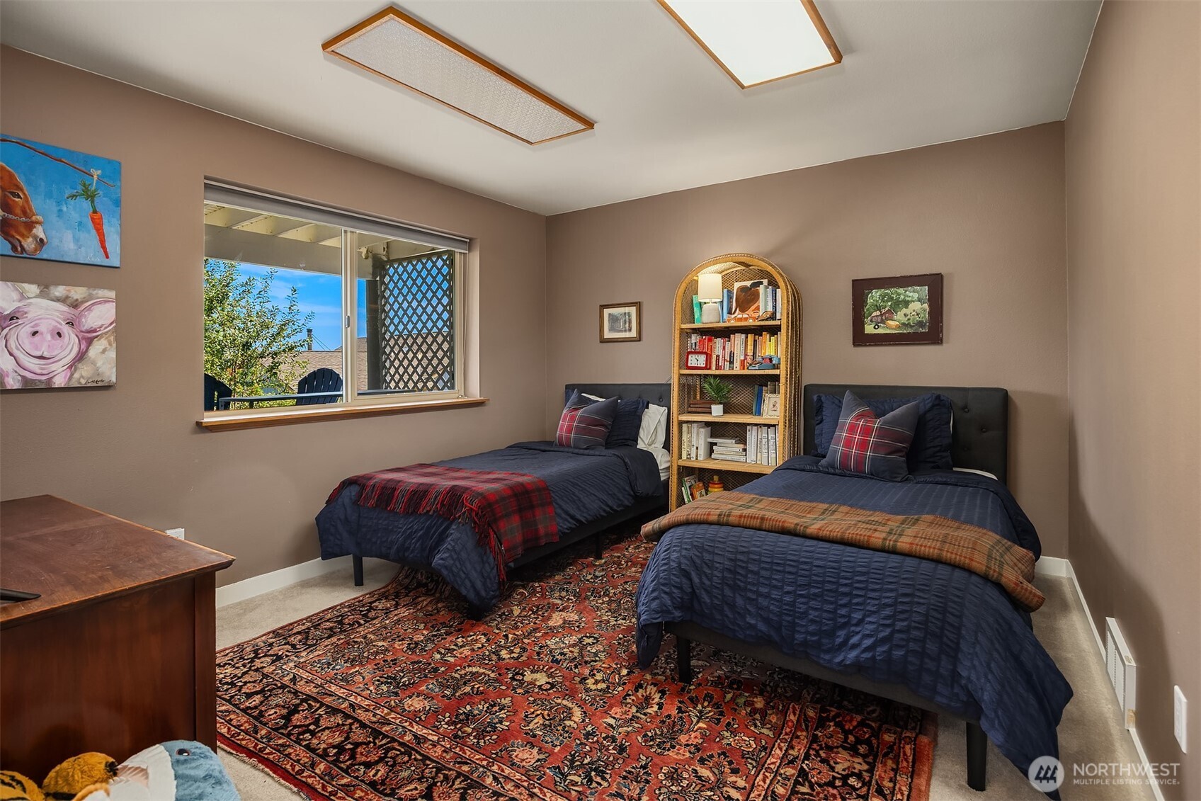 Bedroom with two twin beds, navy bedding, and an arched bookcase between them.
