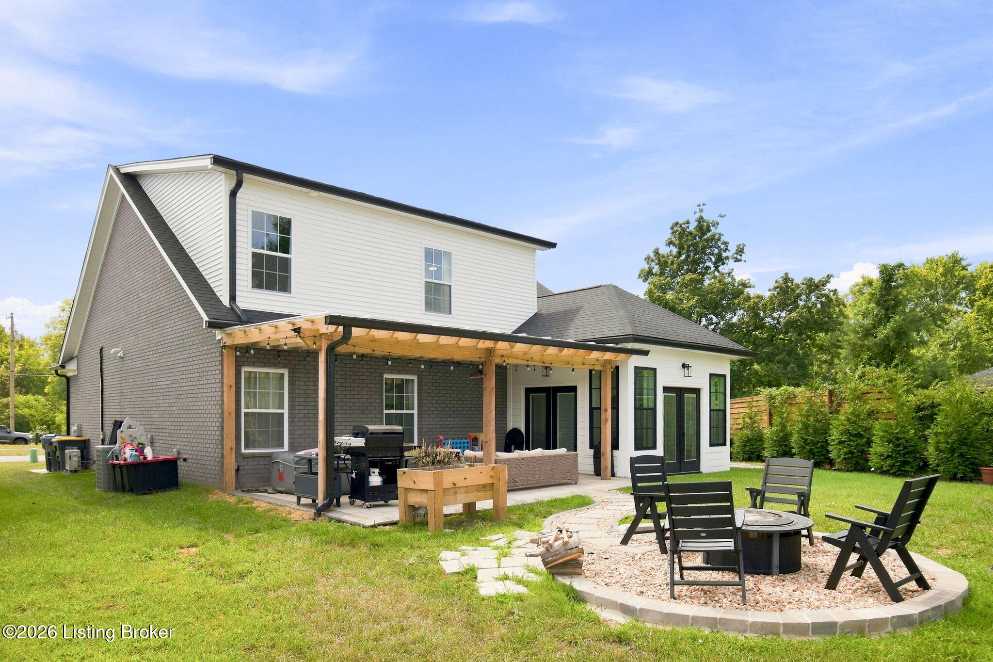 Two-story home with a pergola-covered patio and backyard fire pit seating.