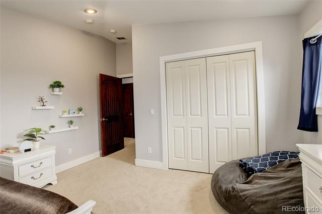 Bedroom with white double closet doors, floating plant shelves, and a gray beanbag.