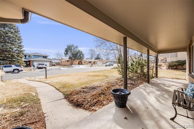 Covered front porch overlooking a dry yard, sidewalk, and residential street.