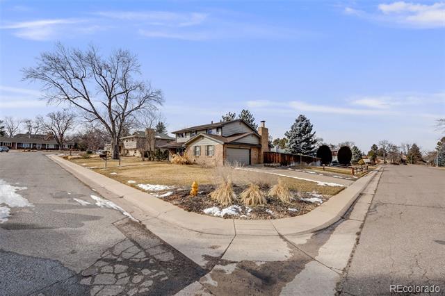 Brick ranch house with attached garage on a snowy corner lot.