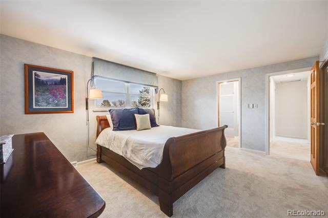 Bedroom with a dark wood bed, white bedding, and a wide window behind the headboard.
