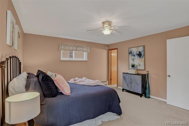 Bedroom with a dark blue bedspread, bedside lamp, and television cabinet.