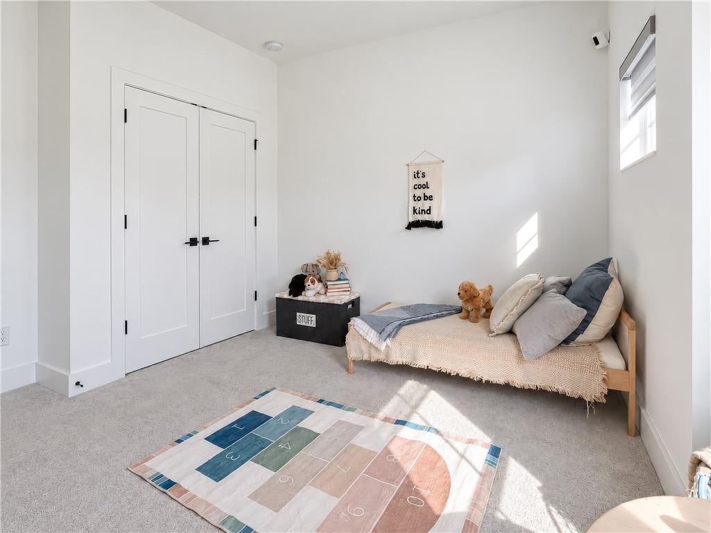 Bright child’s bedroom with a daybed, stuffed animals, and a colorful hopscotch rug.