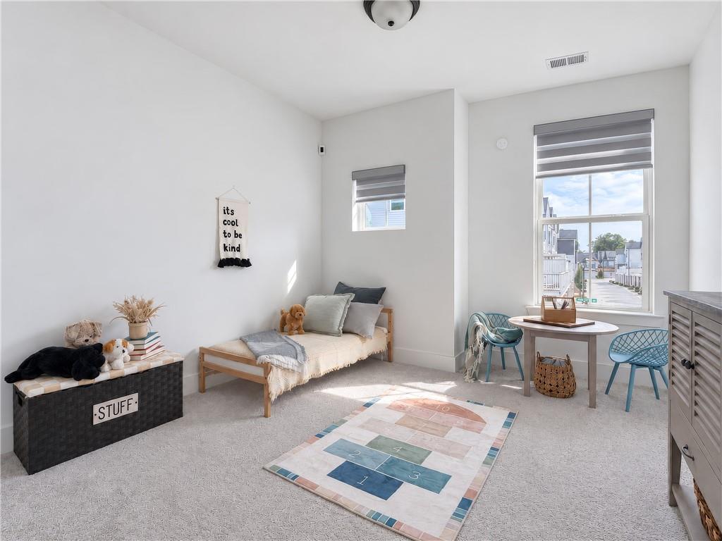 Bright children’s room with a daybed, toys, and a small table beside the window.