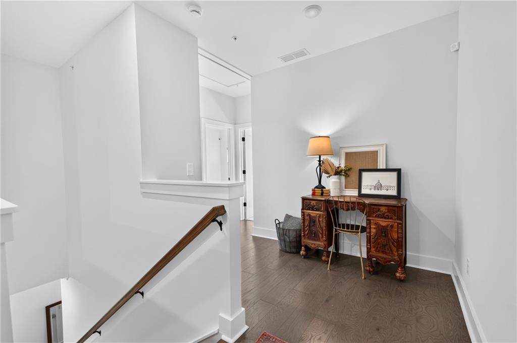Upstairs landing with a carved wood console table beside the staircase.