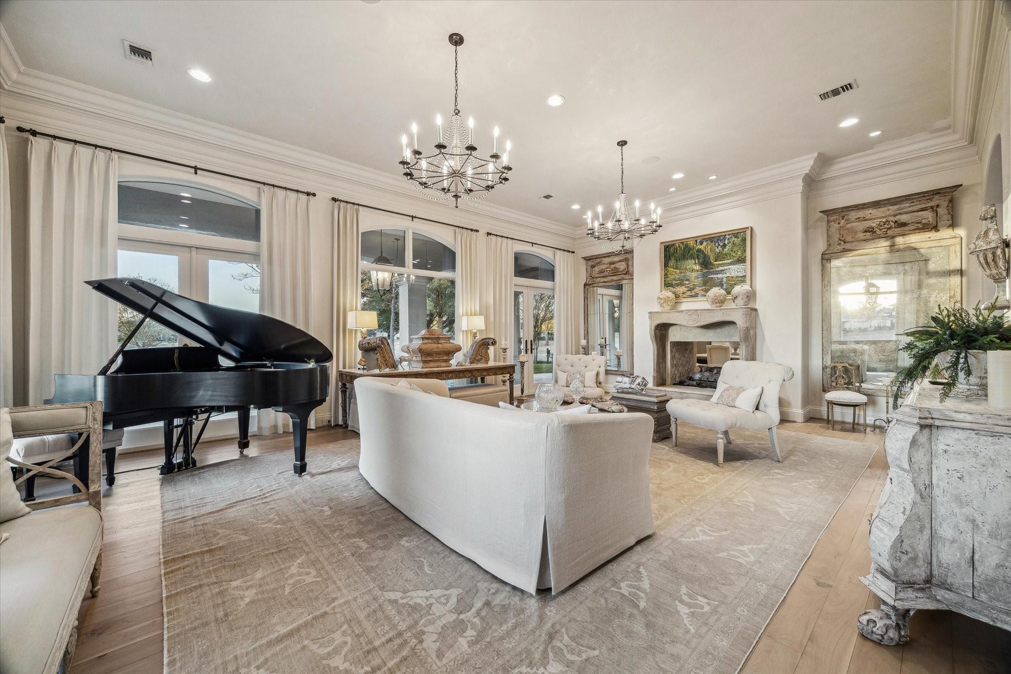 Elegant living room with a black grand piano, cream seating, and a stone fireplace.