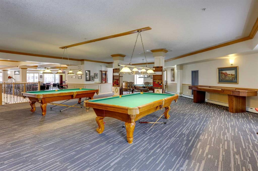 Games room with two pool tables and a wooden game table along the wall.