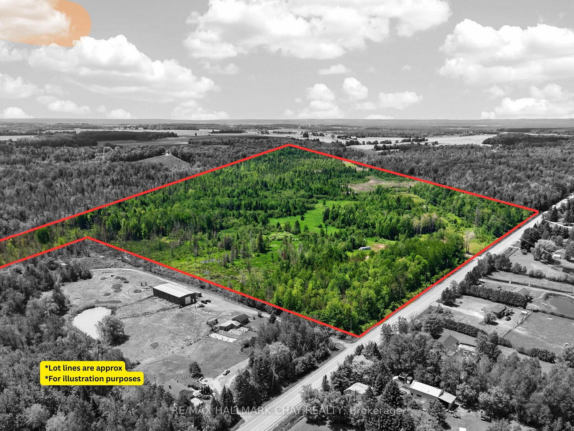 Aerial view of wooded acreage outlined in red, with grassy clearings and road frontage.