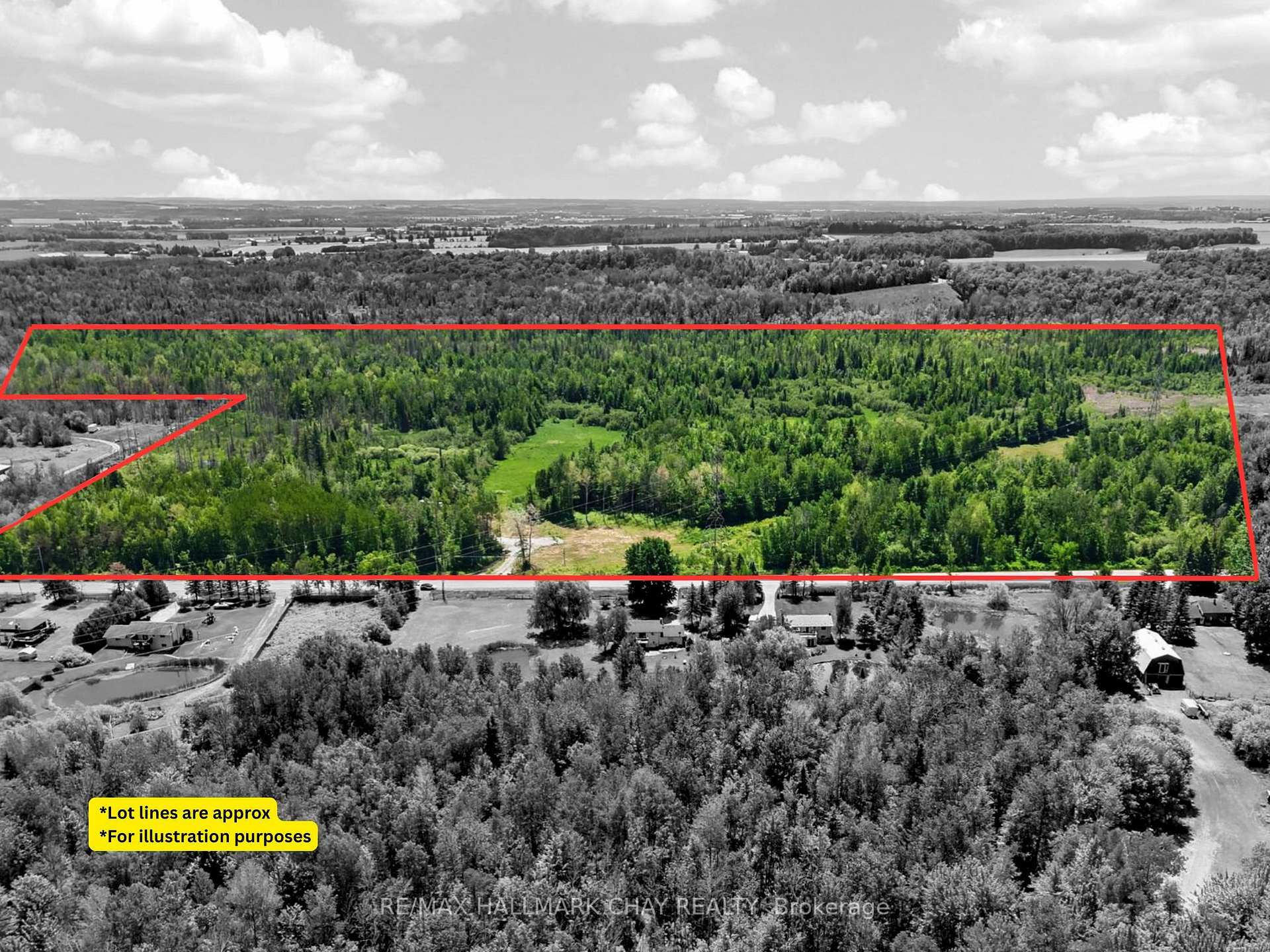 Aerial view of a wooded property outlined in red, with a clearing near the center.