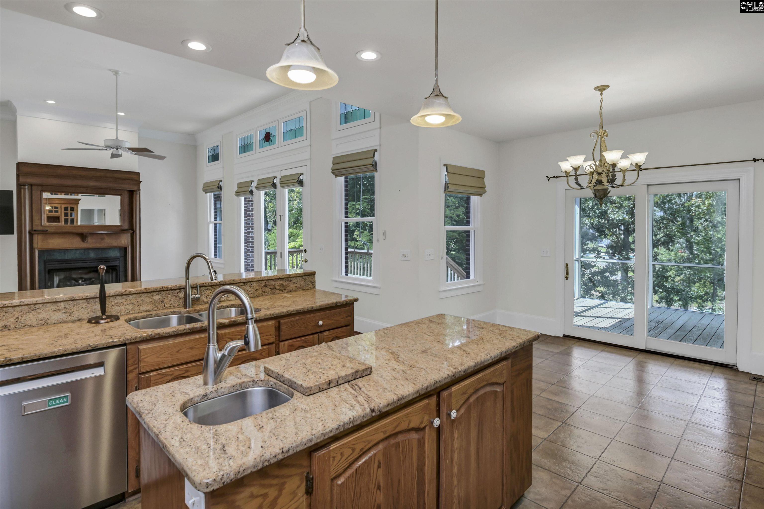 Kitchen with granite counters and a large wood island, opening to a deck through sliding glass doors.
