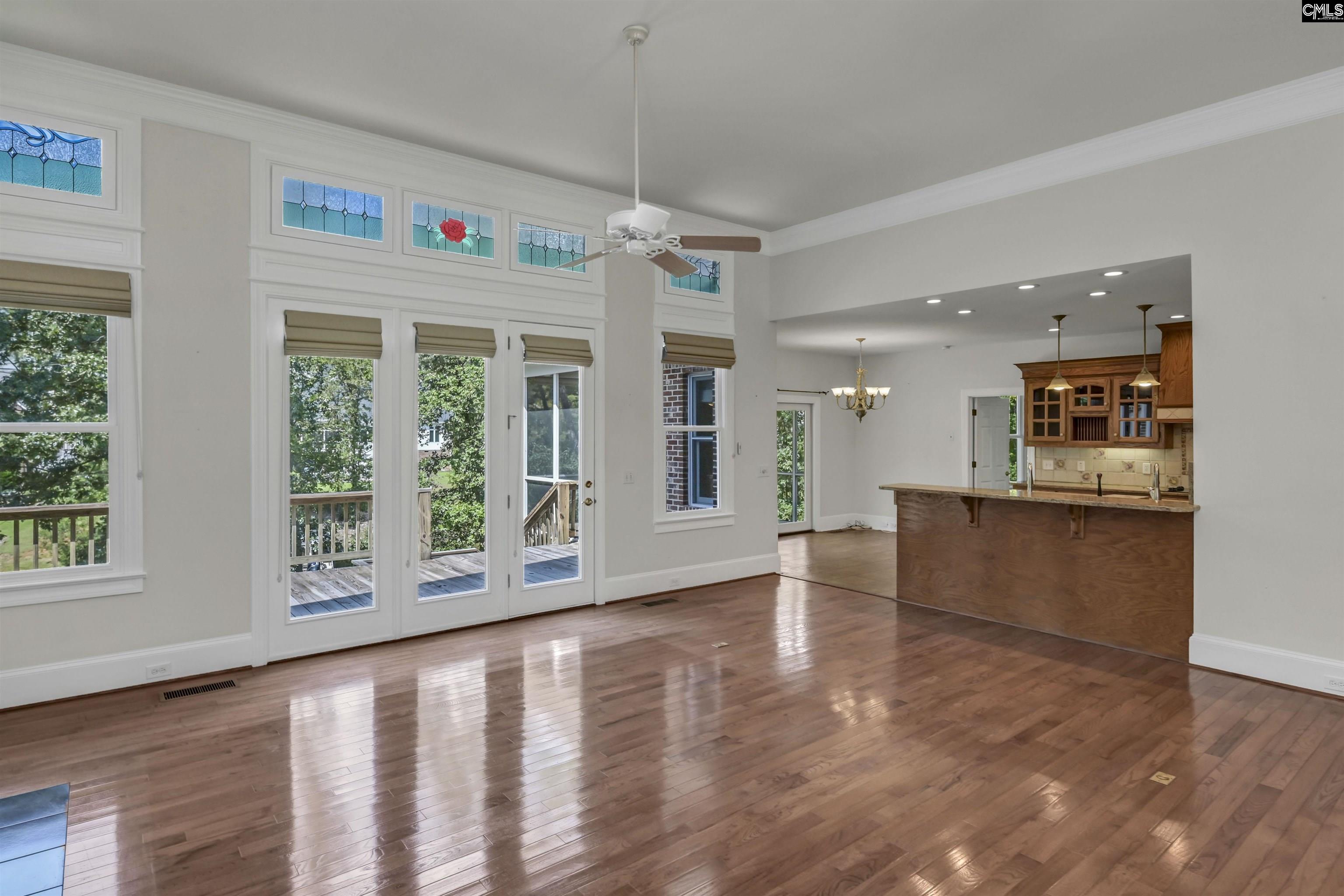 Open living and dining area with hardwood floors, stained-glass transoms, and a large kitchen island.