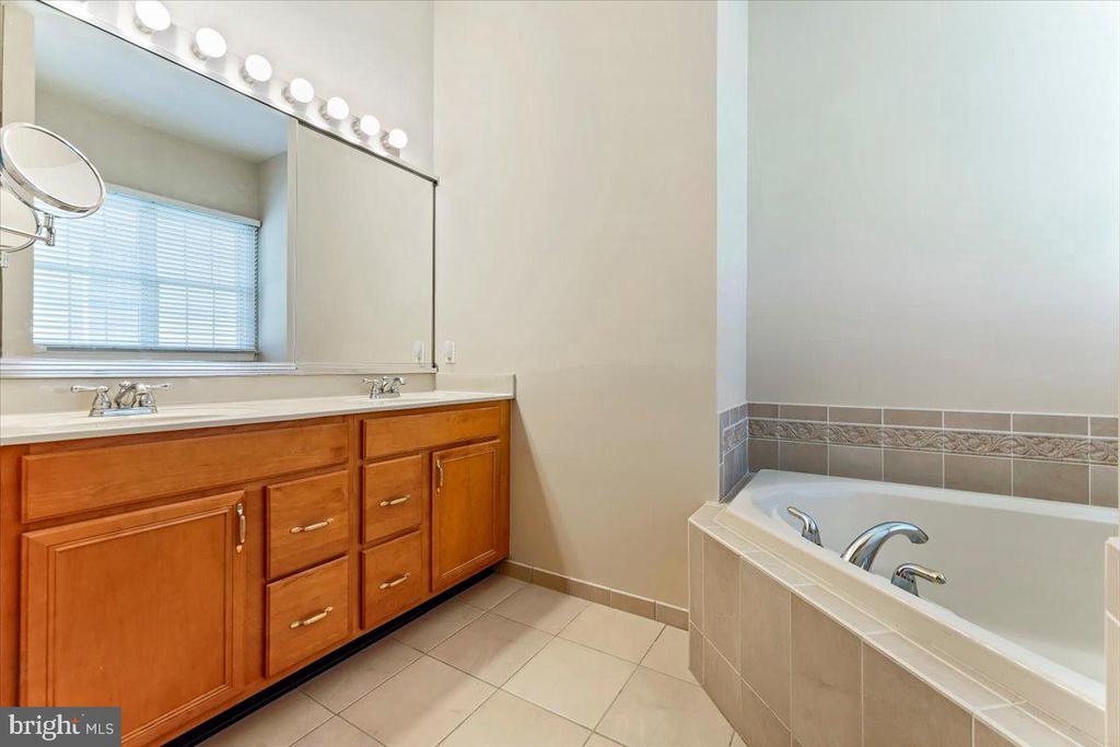 Bathroom with a double-sink vanity and a built-in tiled bathtub.