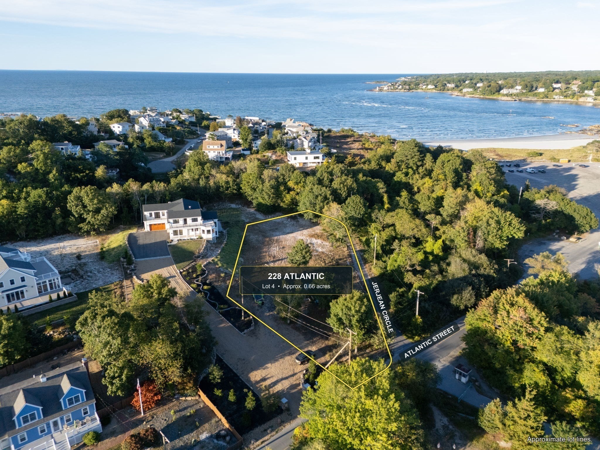 Aerial view of the wooded coastal lot at 228 Atlantic Street, outlined beside neighboring homes and the ocean.