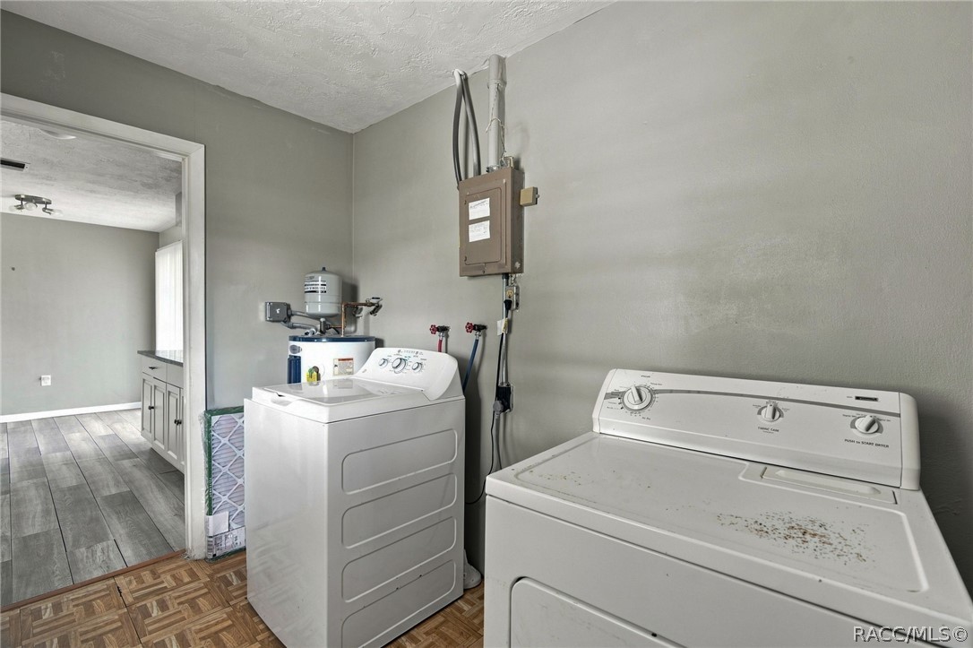 Laundry room with washer, dryer, and utility sink beside an open doorway.