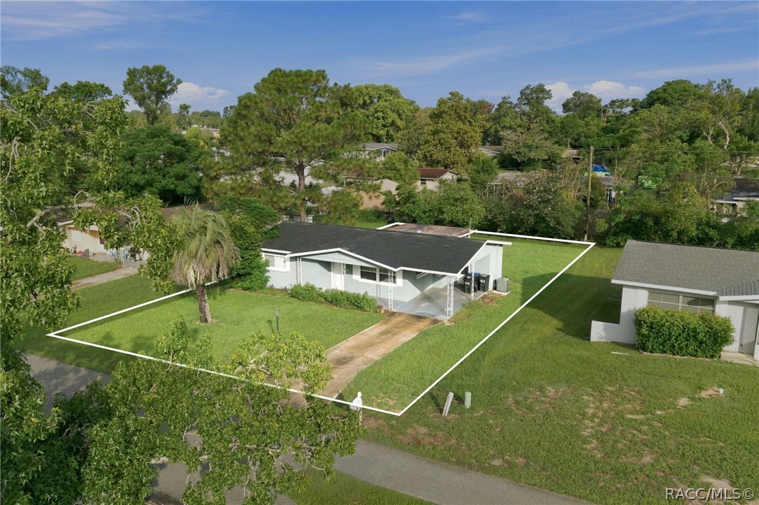 Aerial view of a single-story home and its outlined grassy lot.