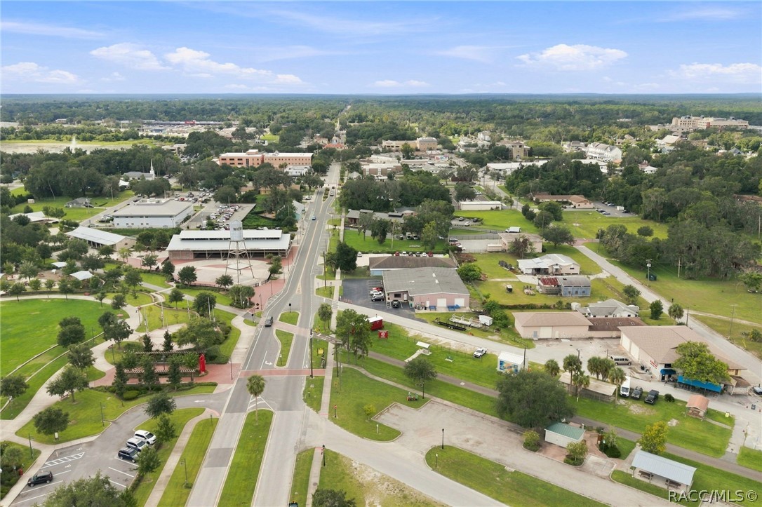 Aerial view of downtown, with a main road, low-rise buildings, and green spaces.