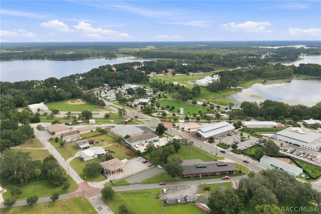 Aerial view of Inverness with commercial buildings, tree-lined roads, and lakes nearby.