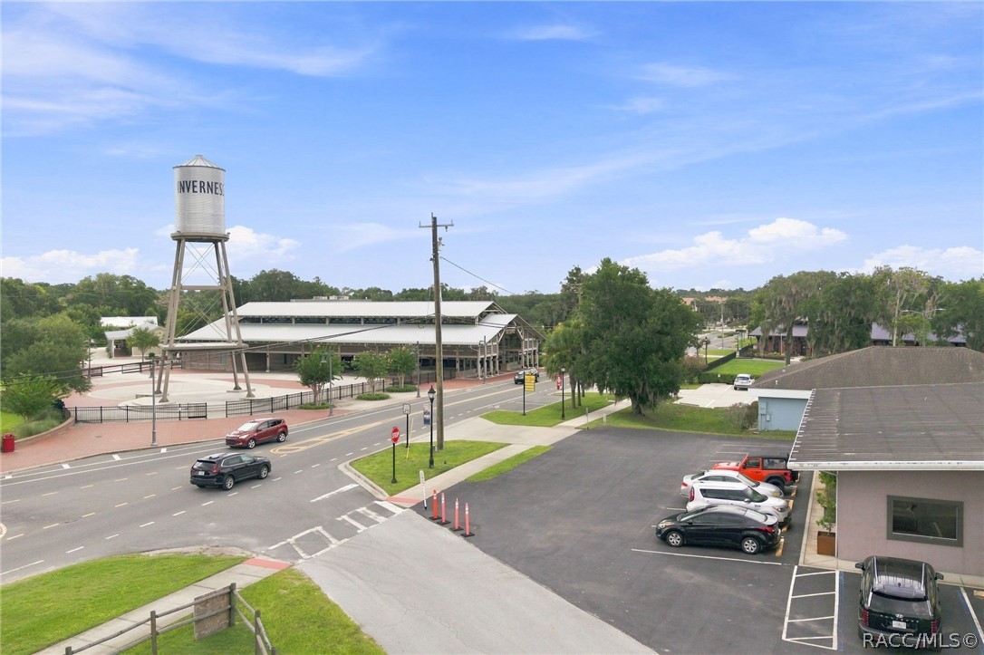 Aerial view of downtown Inverness, with its water tower, commercial buildings, and parking lot.