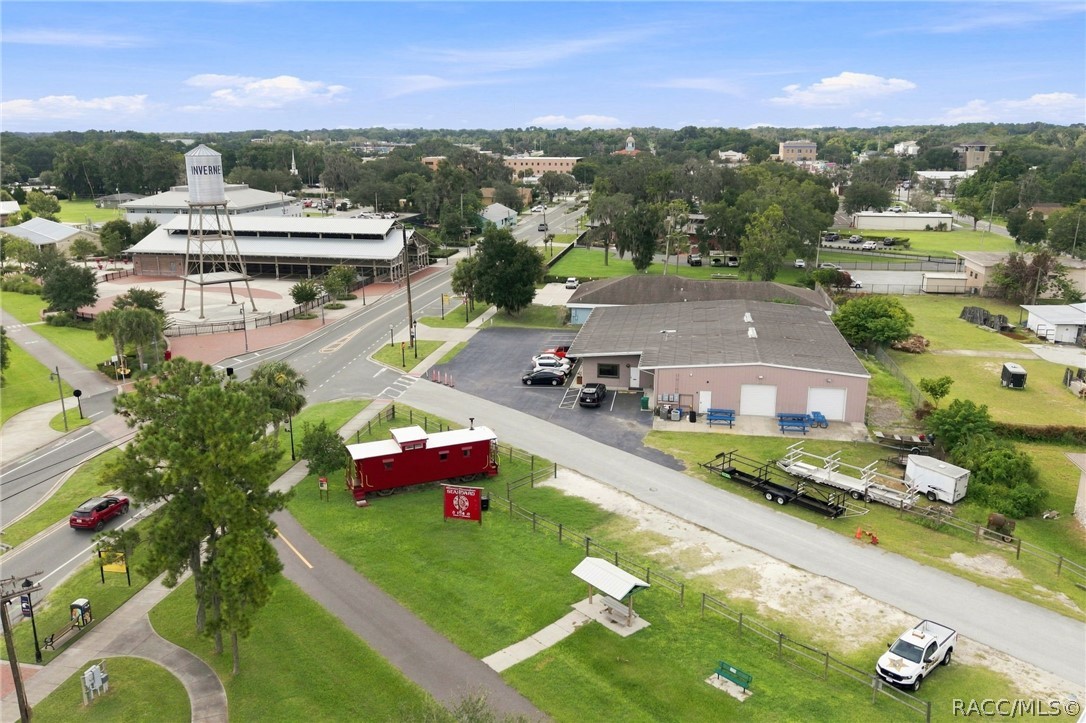 Aerial view of a commercial area with a red building, nearby roads, and the Inverness water tower.